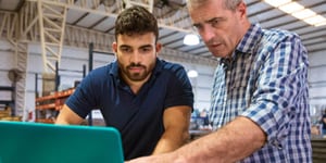 Two men looking at a laptop computer