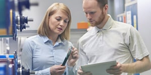 Woman and man looking at a tool