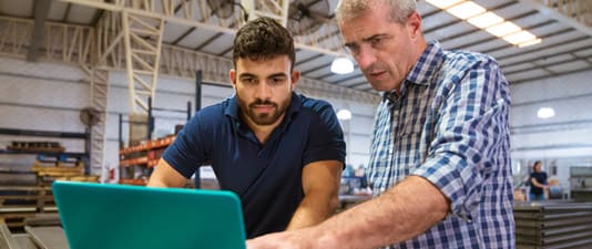 Two men looking at a laptop computer