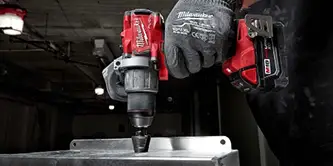 a hand using a Milwaukee M12 tool