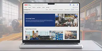 a laptop on a desk in a shop floor with screen showing Knowledge Center website