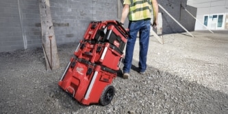worker rolling a Milwaukee PACKOUT tool boxes