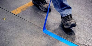 man putting down blue marking tape