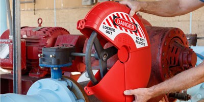 man putting a lockout cover on a valve