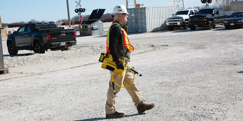 a worker walking while carrying the Enerpac SC hydraulic pump