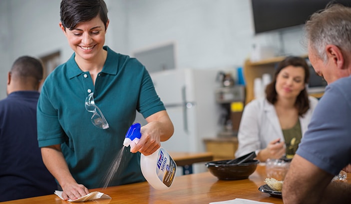 image of woman using Purell spray