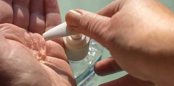 A person using hand sanitizer