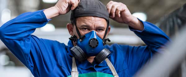 Man wears respirator mask to control the spread of COVID in the workplace