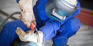man welding wearing protective equipment