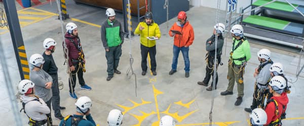 a group of people in safety gear standing in a circle