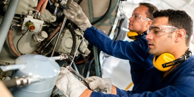 Two workers fixing a engine