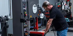 Worker using a vertical bandsaw in the shop